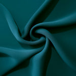 Deep Teal silky-soft polyester crepe styled in a swirl to show fluid dressmaking drape and movement