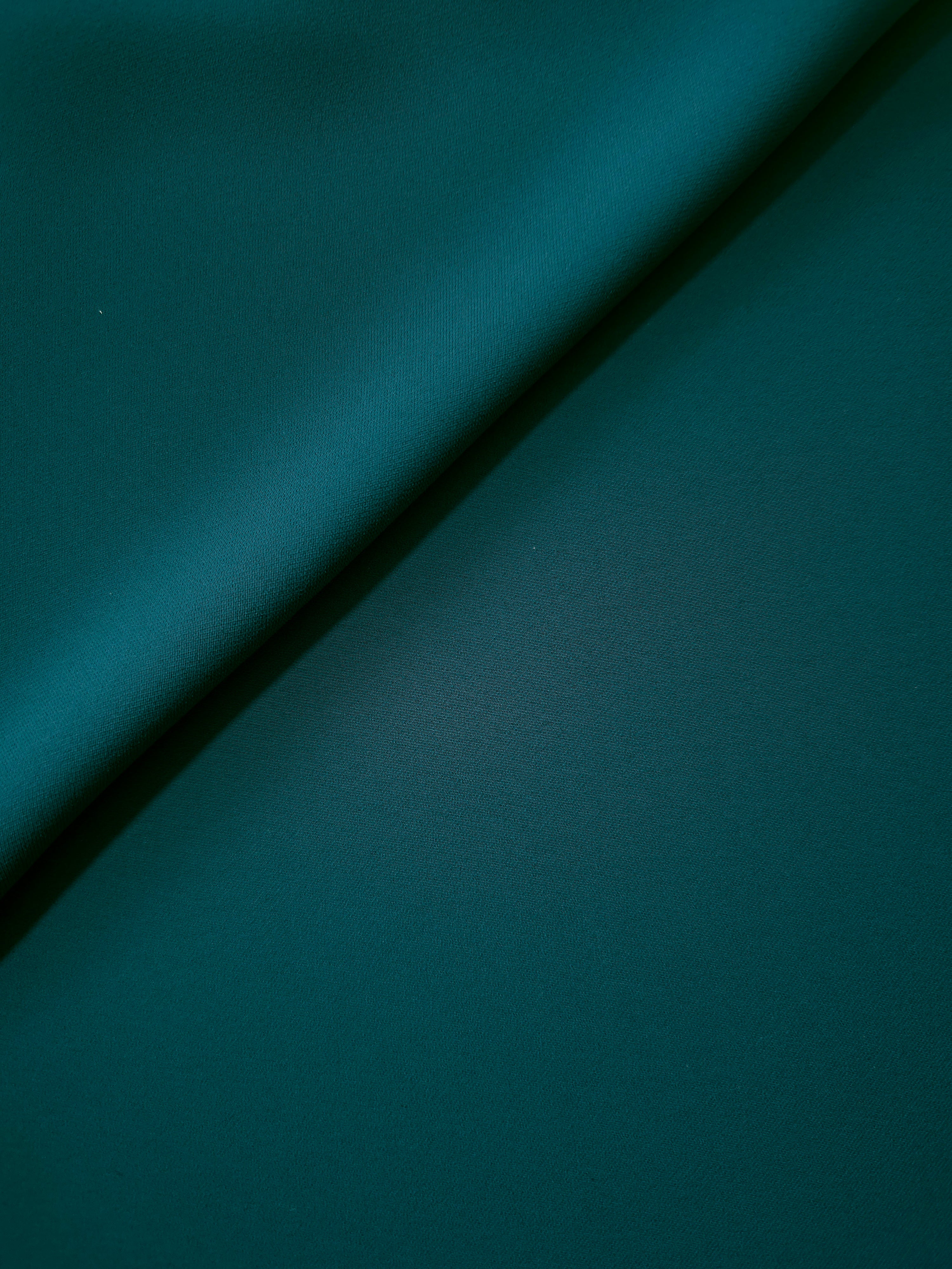 Deep Teal opaque Korean polyester crepe in a soft fold, showing flowing drape for garment making