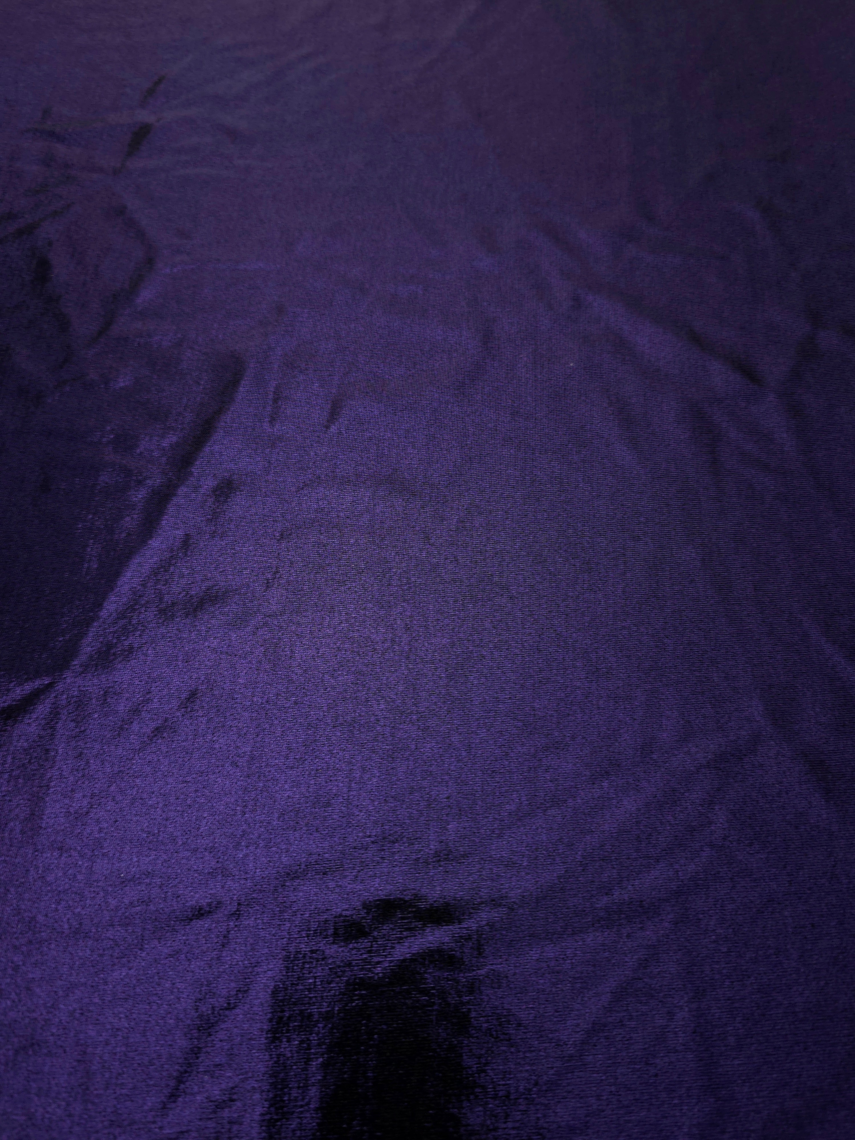 Full surface of Deep Violet Purple metallic stretch fabric, highlighting luminous foil sheen for stage costumes, dresses and fashion design