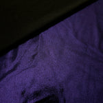 Gently folded Deep Violet Purple shimmer spandex fabric showing luminous foil finish for tops, skirts and occasion garments