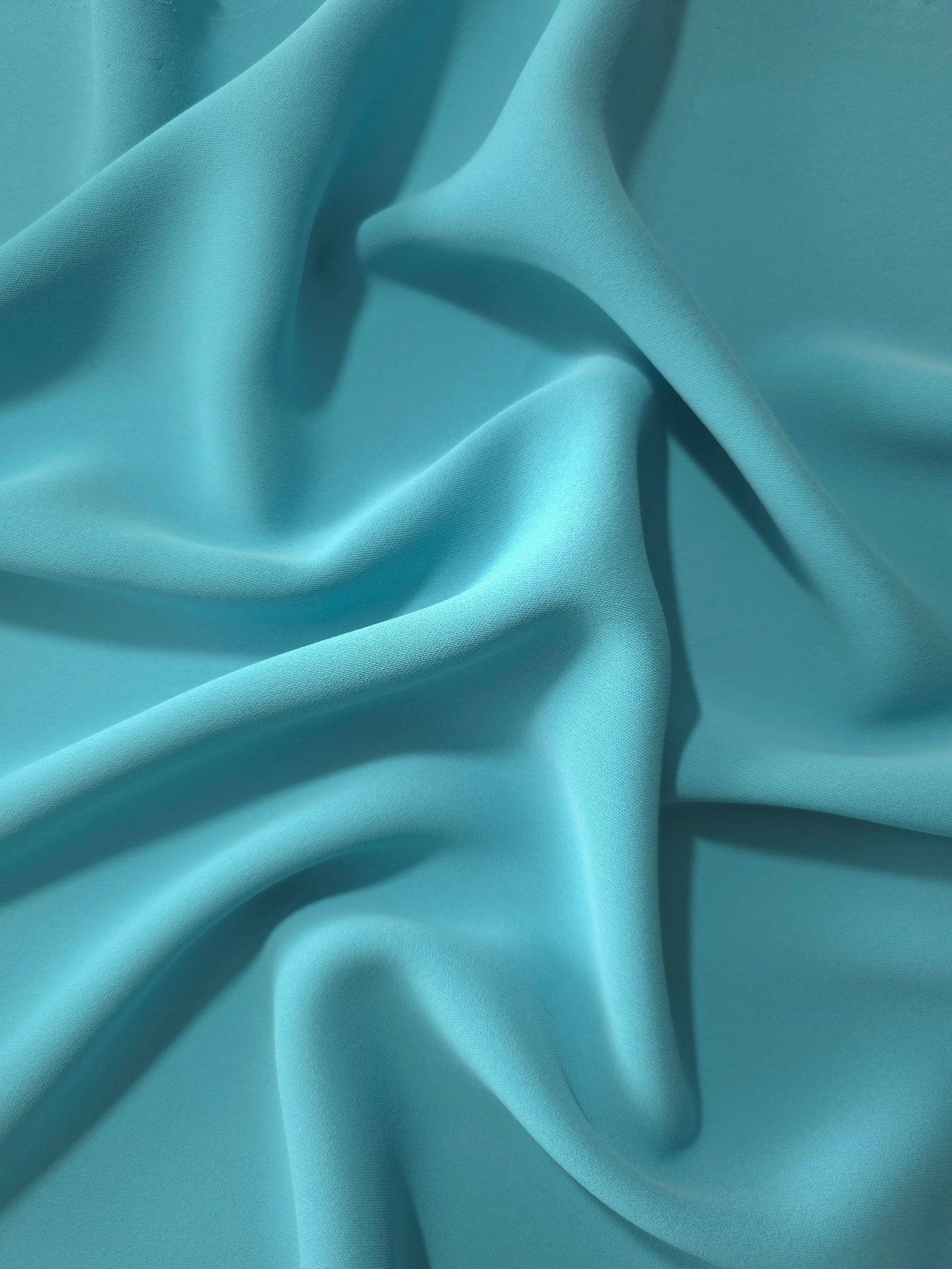 Long draped folds of Dusty Aqua Blue Korean crepe showing opaque coverage for abayas, dresses and modest wear
