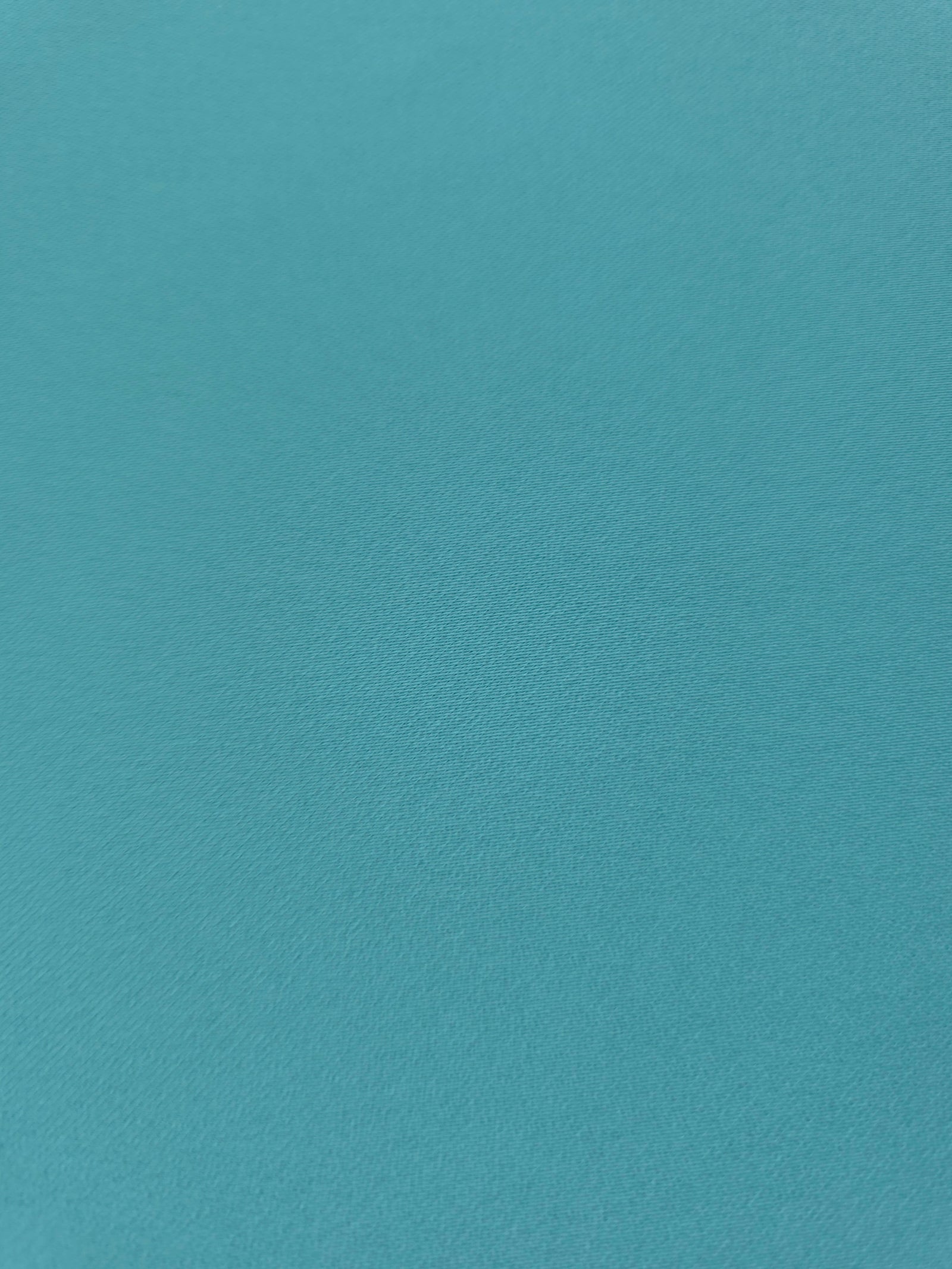 Fine texture close-up of Dusty Aqua Blue 100% mechanical polyester crepe showing a smooth, silky-soft woven hand