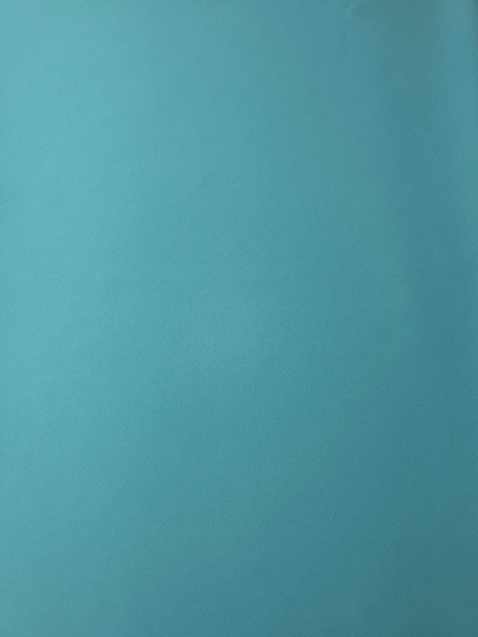 Flat surface of Dusty Aqua Blue Korean crepe, a 205 GSM opaque polyester fabric with smooth dressmaking character