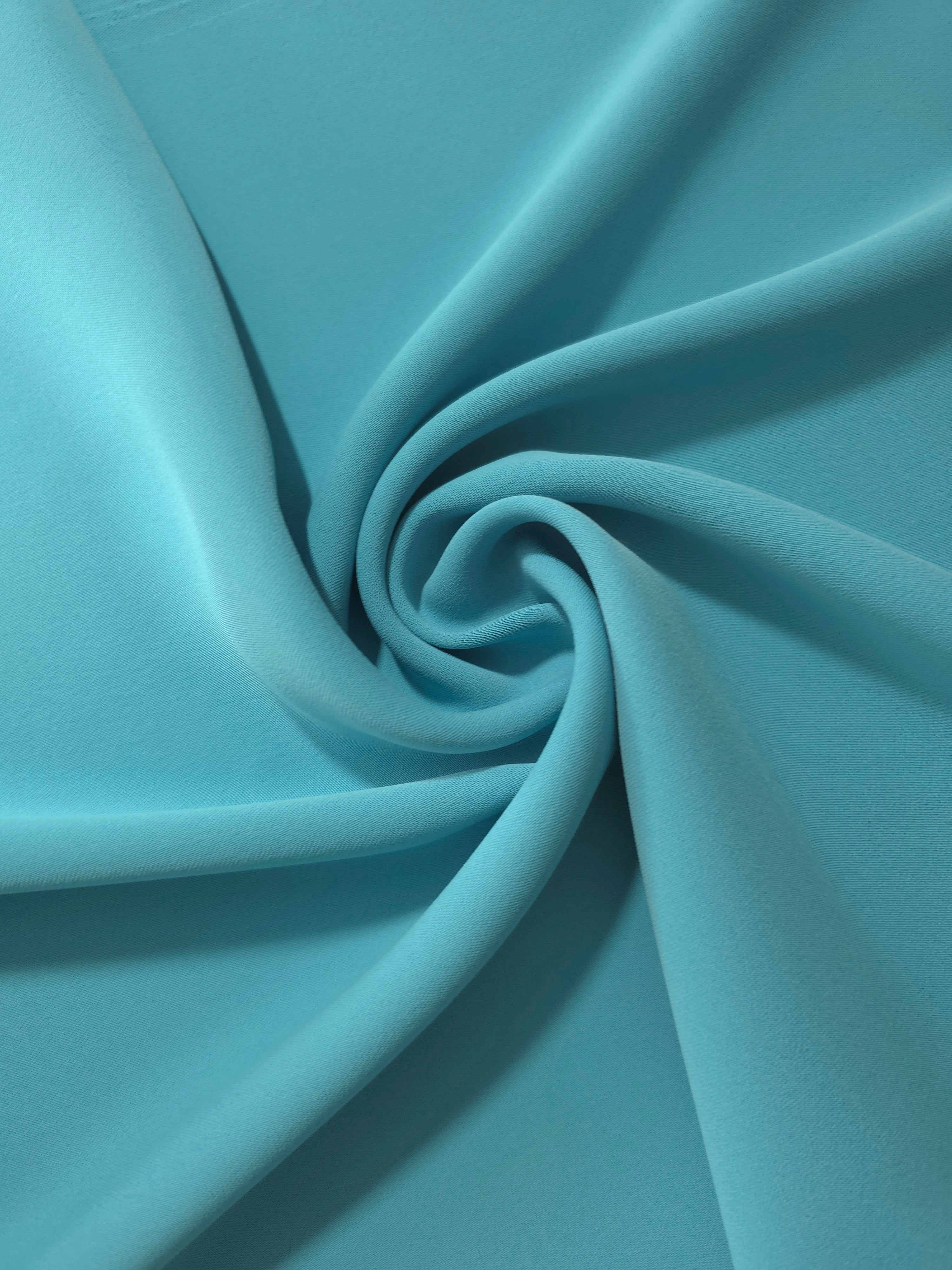 Circular drape of Dusty Aqua Blue polyester crepe showing flowing movement for occasion dresses and modest fashion