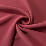 Dusty Burgundy opaque polyester crepe in a spiral drape, showing flowing form for skirts and modest garments