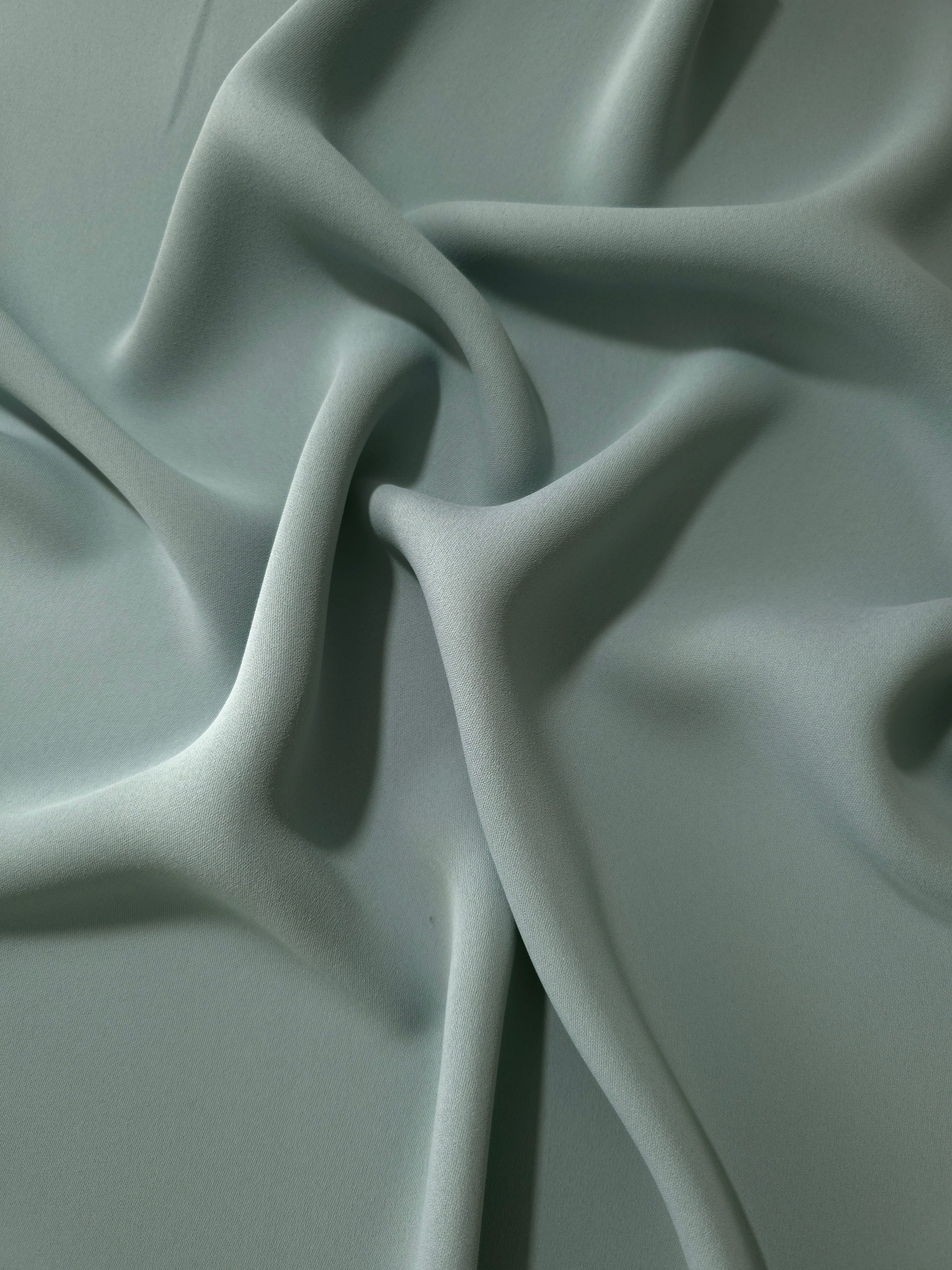 Draped Dusty Eucalyptus Green Korean polyester crepe showing opaque fluid folds for evening dresses and occasionwear