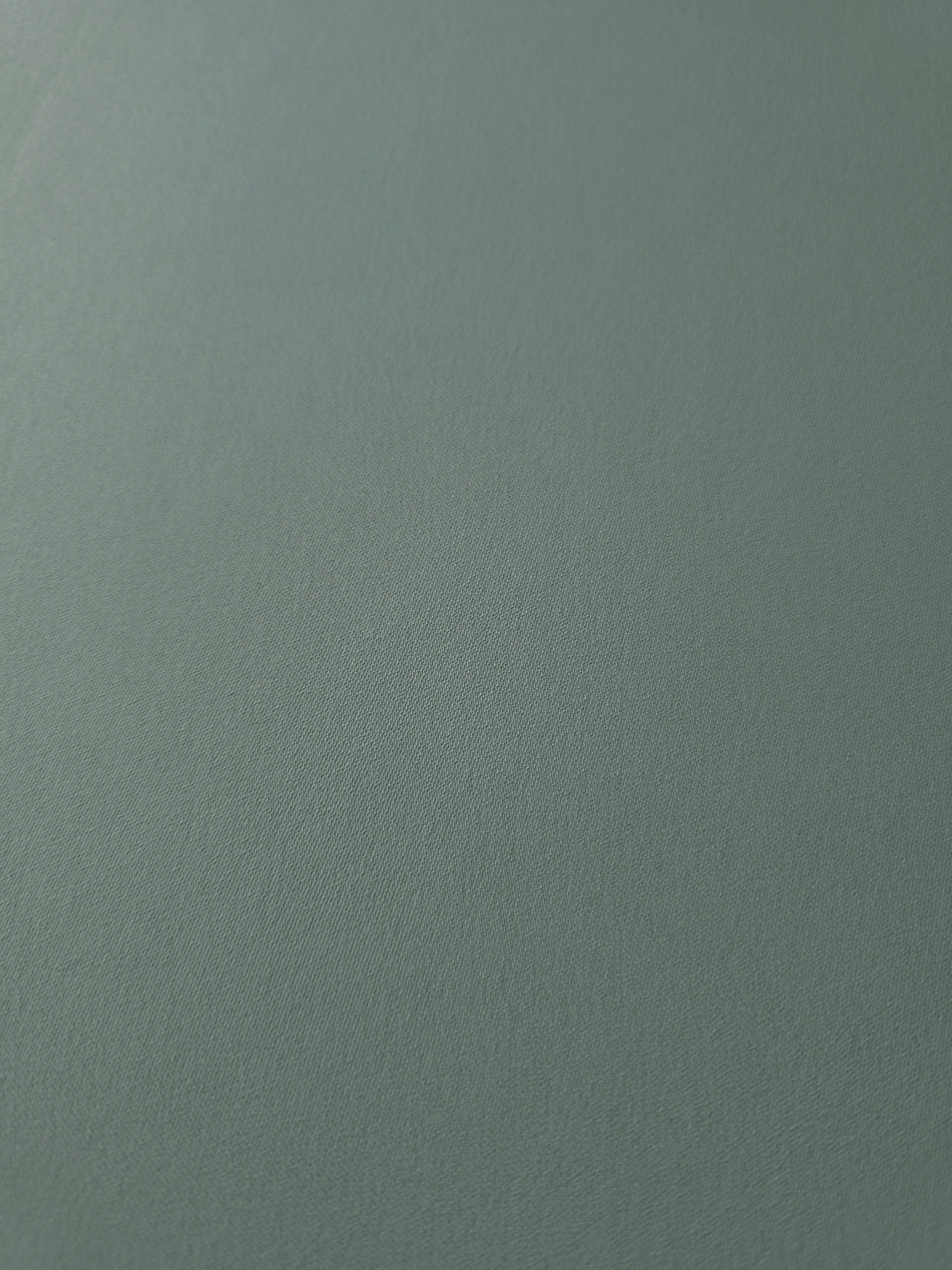 Close-up of Dusty Eucalyptus Green 100% mechanical polyester crepe showing fine woven texture and a silky-soft hand feel