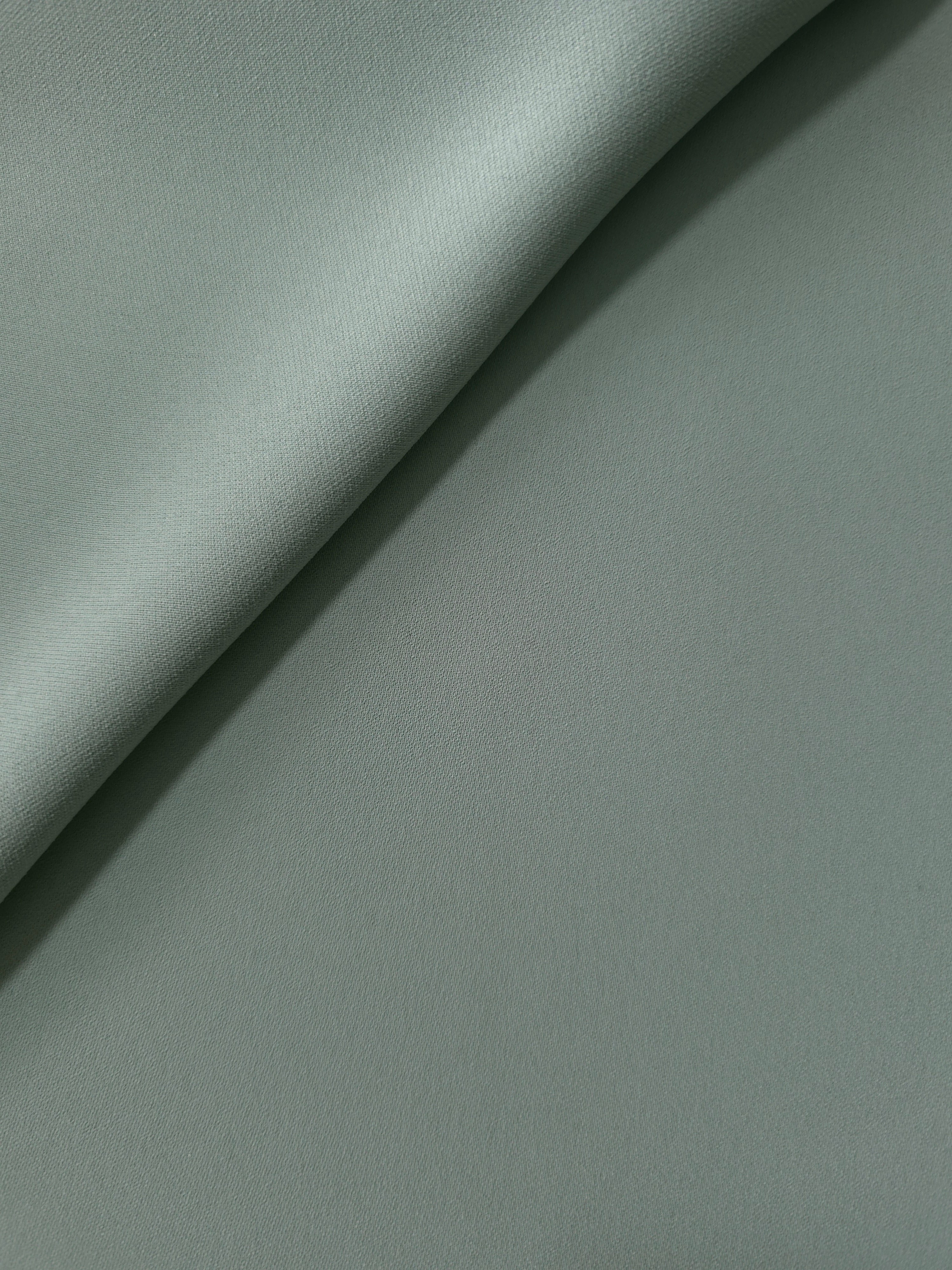 Dusty Eucalyptus Green Korean polyester crepe in a soft fold, showing fluid drape for blouses and flowing dresses
