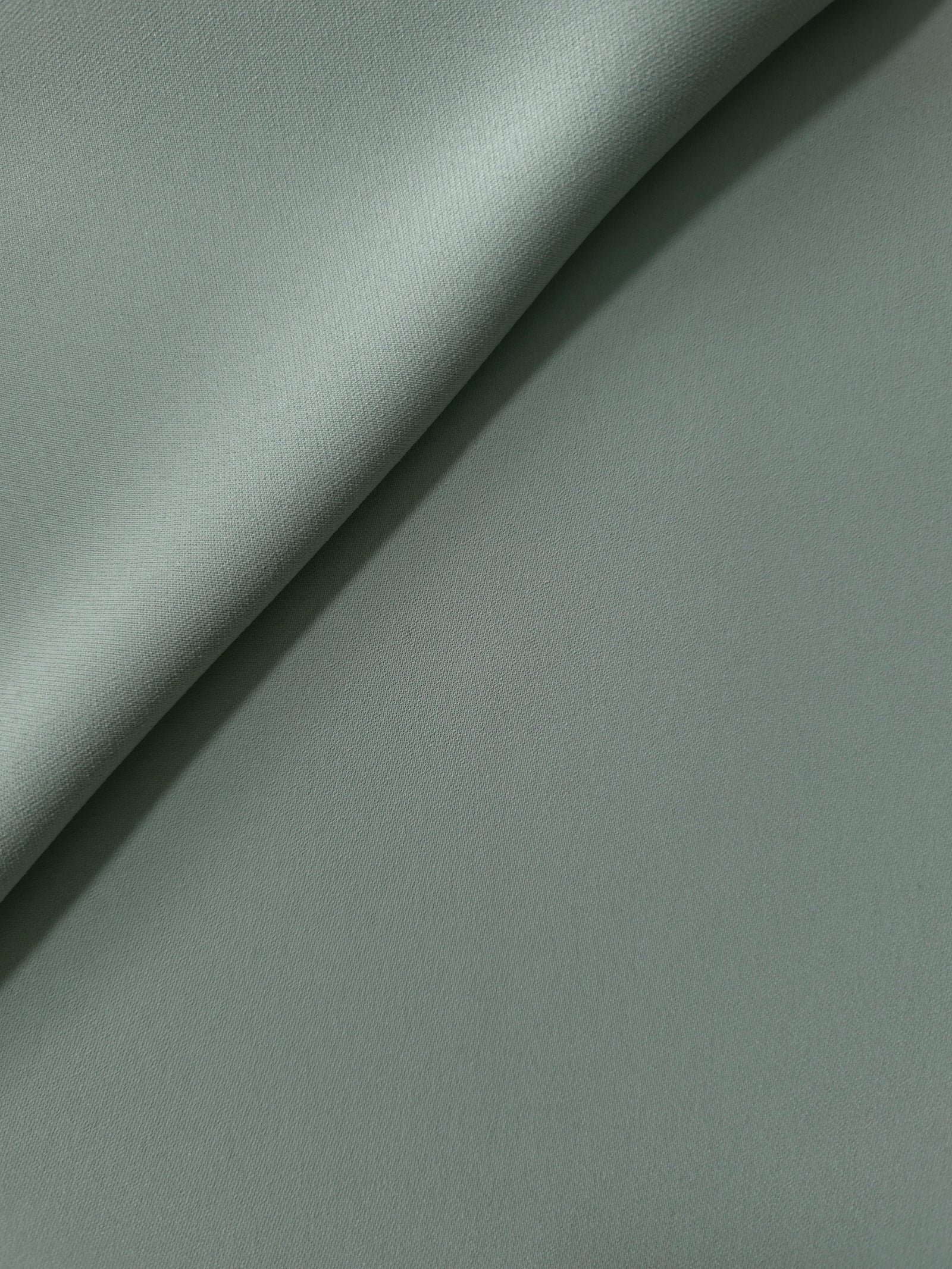 Dusty Eucalyptus Green Korean polyester crepe in a soft fold, showing fluid drape for blouses and flowing dresses