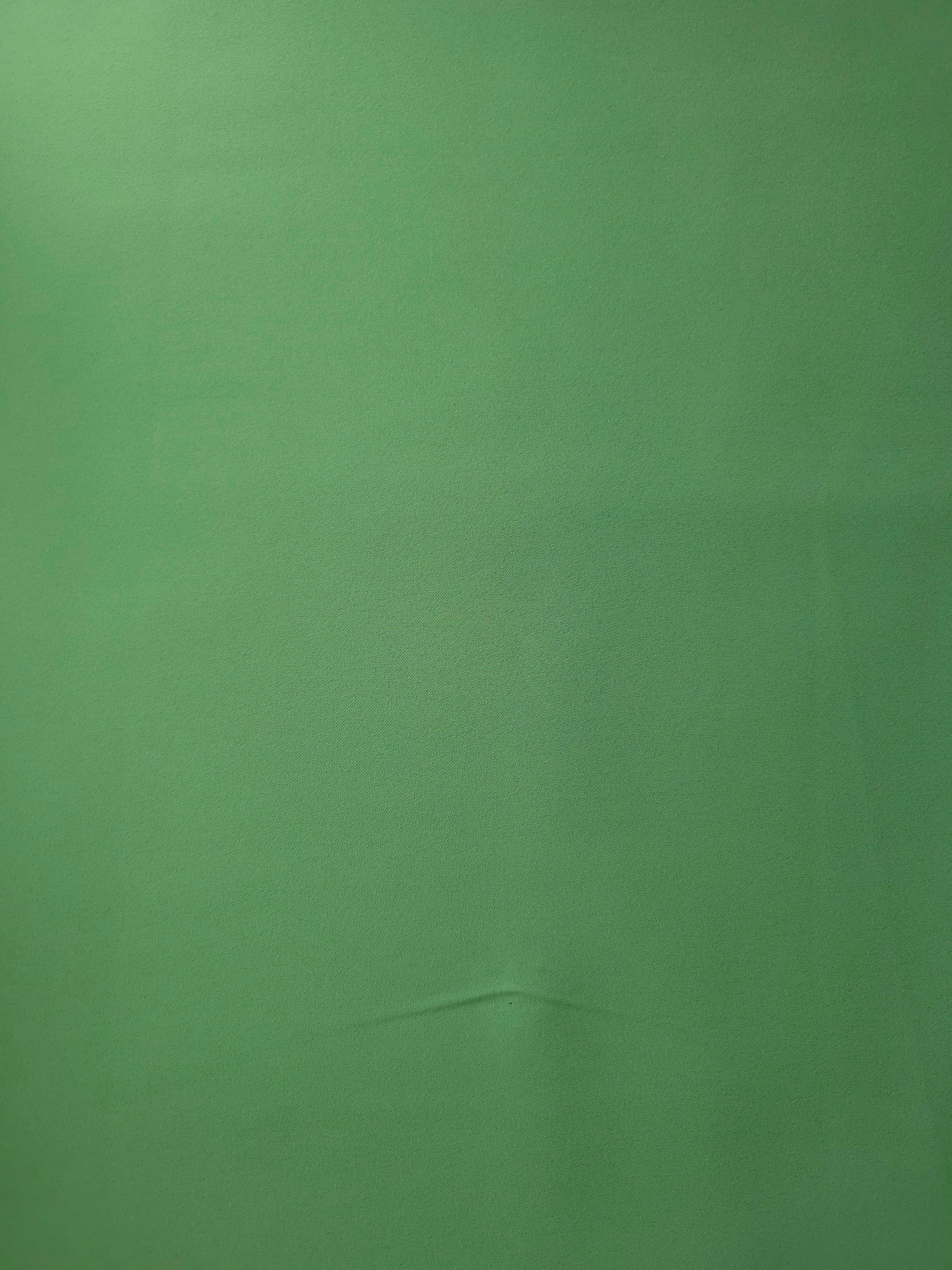 Flat lay of Dusty Fern Green polyester crepe, smooth Italian-style apparel fabric with a soft refined finish