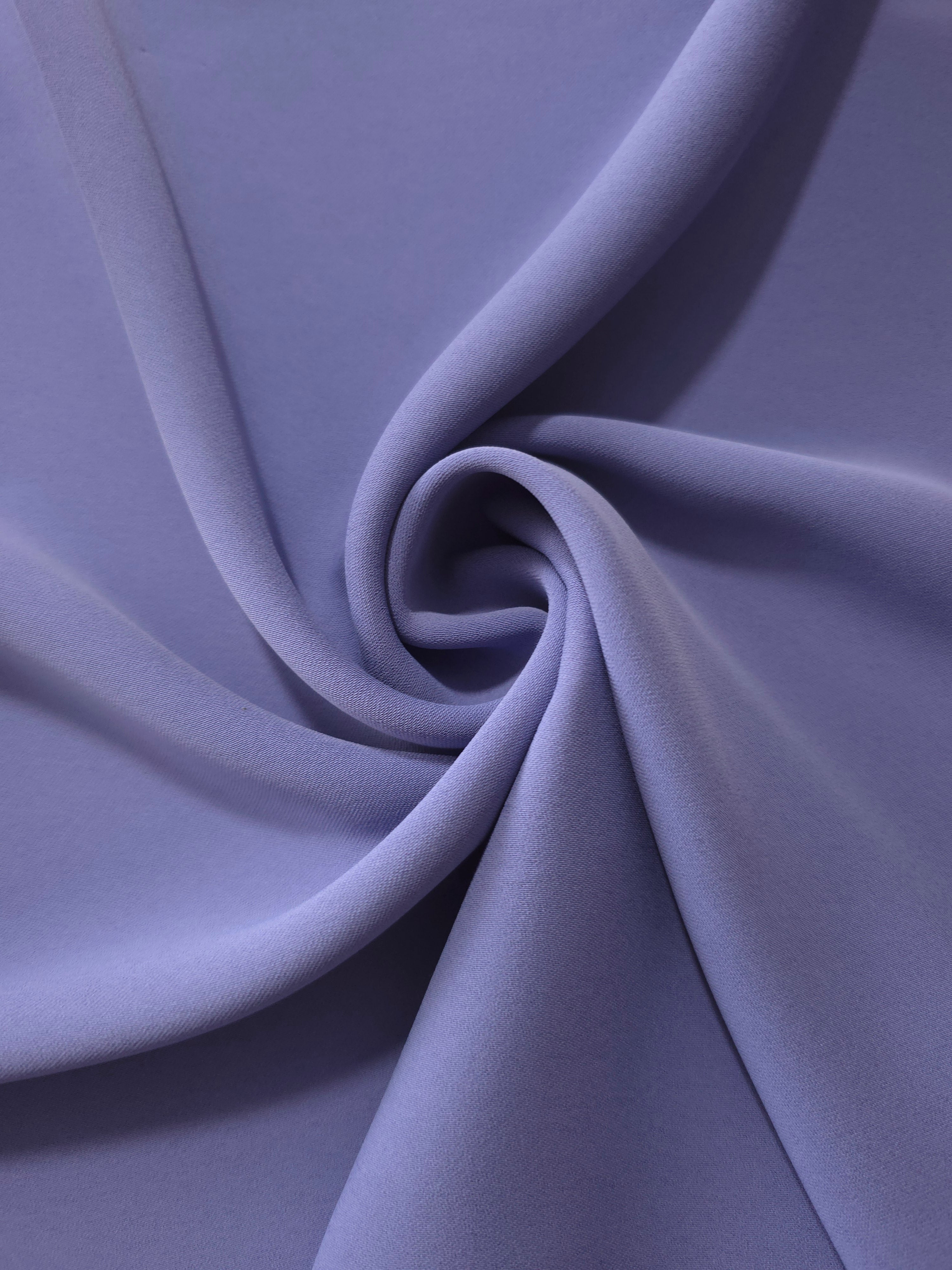 Dusty Indigo Blue opaque polyester crepe in a spiral drape, showing flowing form for skirts and modest garments