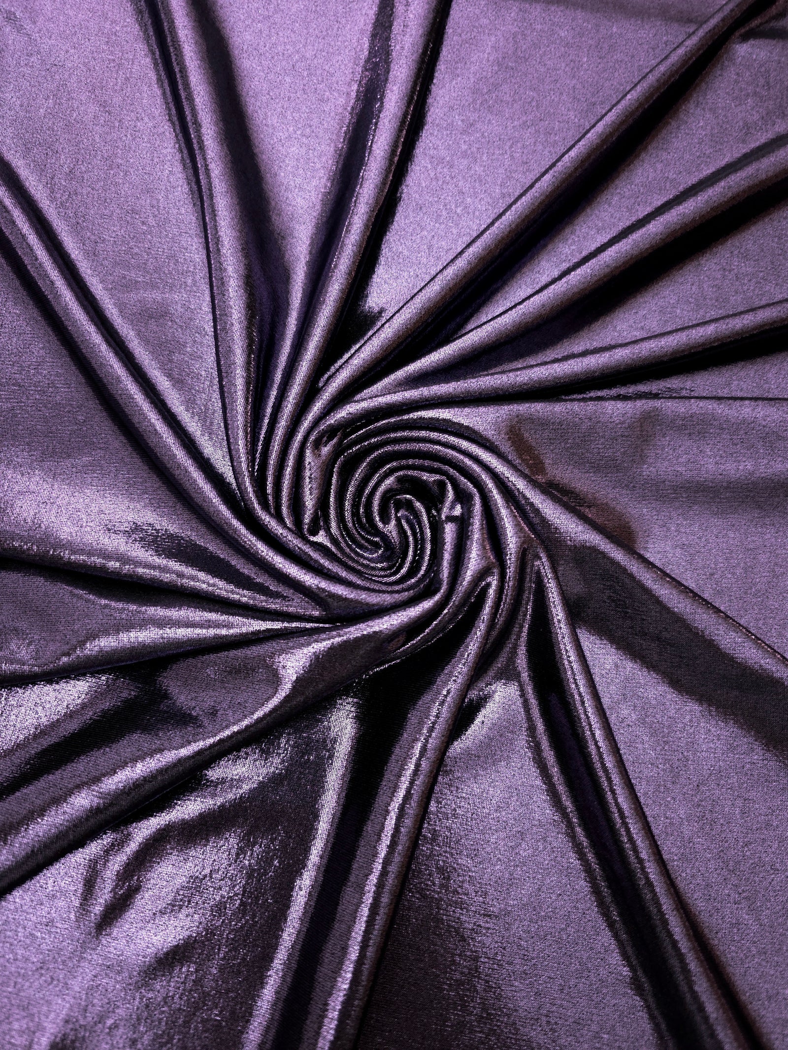 Flowing swirl of Dusty Lavender Purple metallic stretch fabric, showing dynamic foil reflection for stagewear, skirts and creative fashion