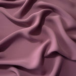 Draped folds of Dusty Mauve polyester crepe showing opaque coverage and fluid movement for garment making