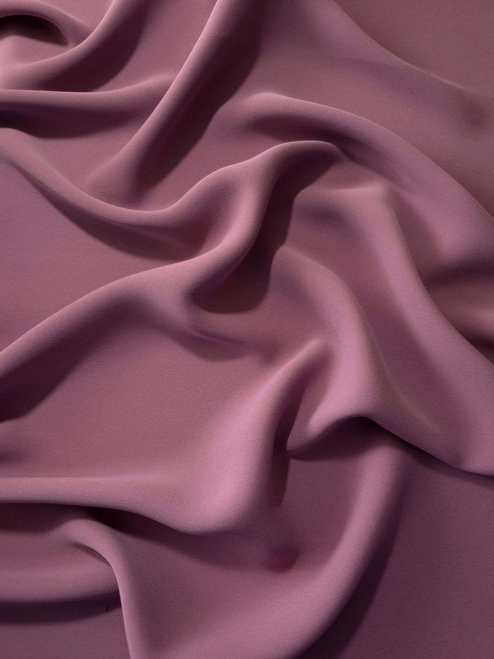 Draped folds of Dusty Mauve polyester crepe showing opaque coverage and fluid movement for garment making