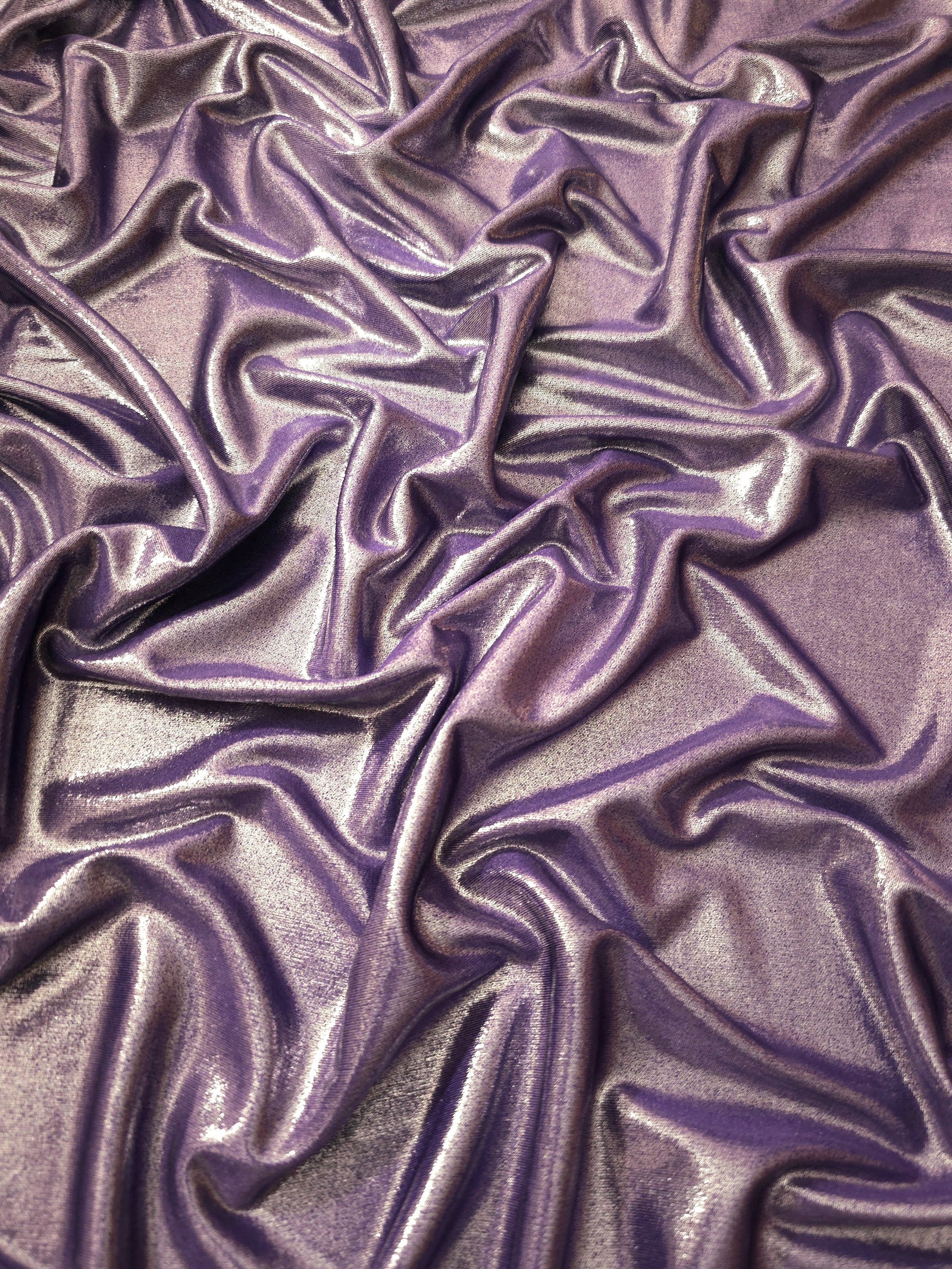 Flowing folds of Dusty Mauve Gray metallic foiled spandex, showing shimmer and drape for dancewear, party dresses and performance fashion