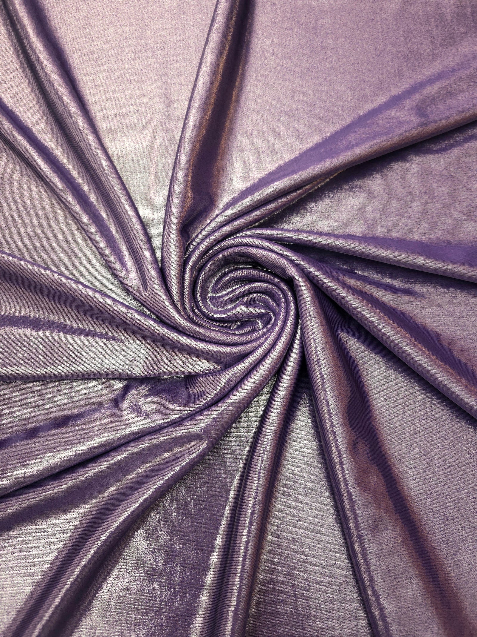 Dusty Mauve Gray metallic stretch fabric in a flowing swirl, emphasizing foil shimmer and drape for partywear and statement fashion
