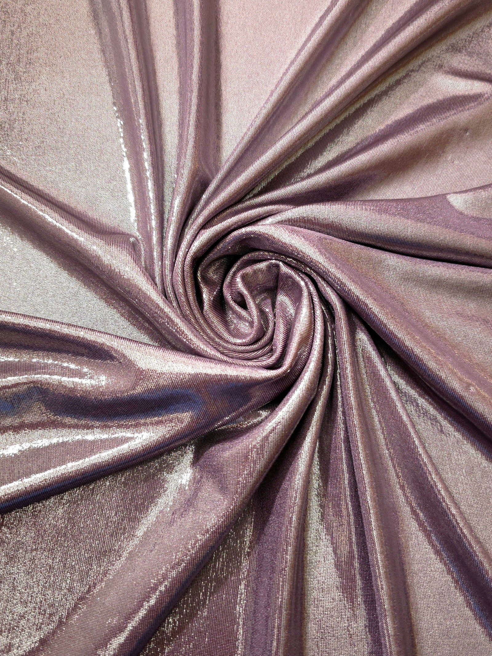 Dusty Mauve Gray shimmer foiled stretch fabric arranged in a swirl, highlighting movement and reflective finish for performancewear