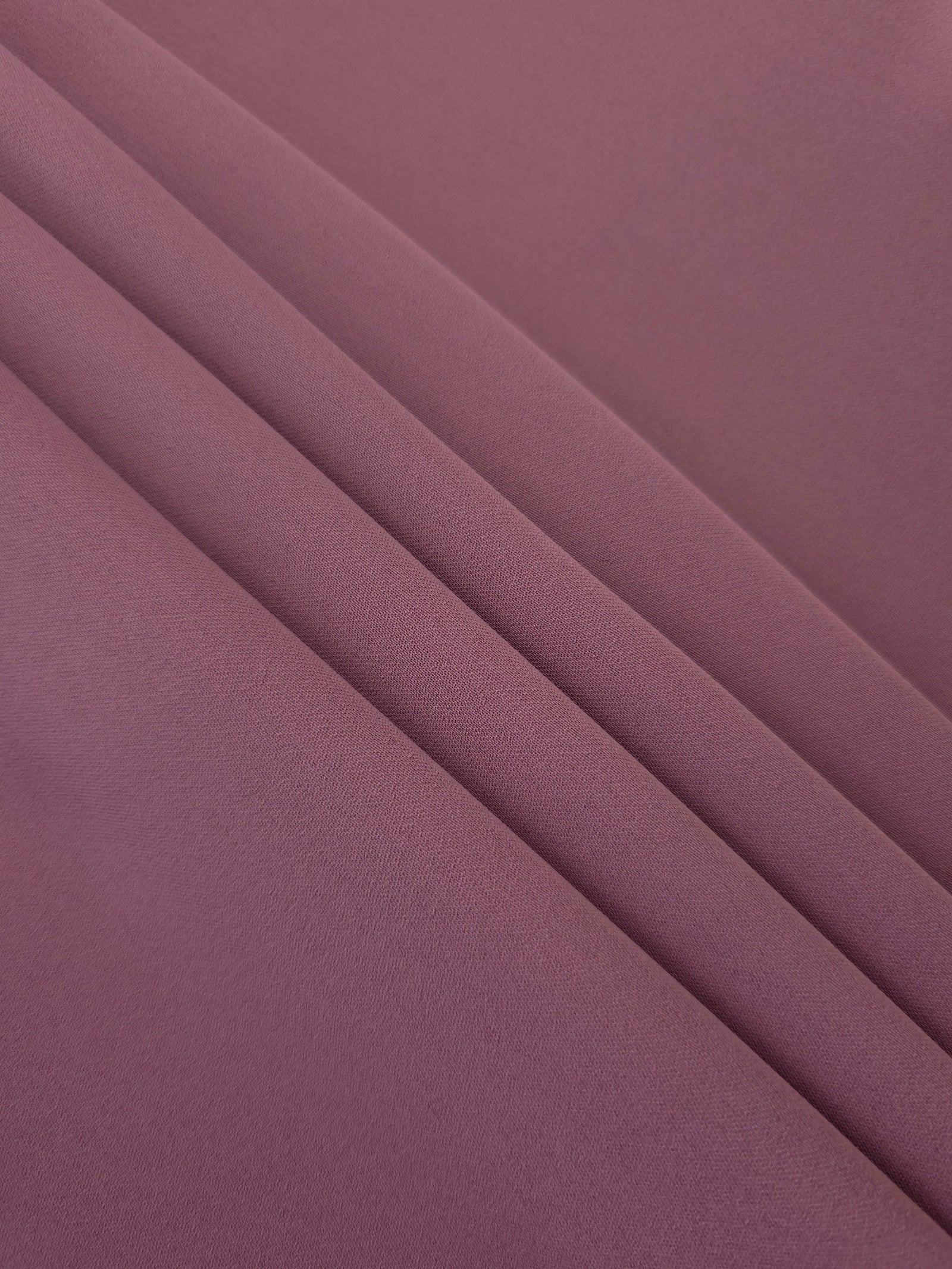 Layered Dusty Mauve Korean polyester crepe showing gentle mechanical stretch and soft structure for dressmaking