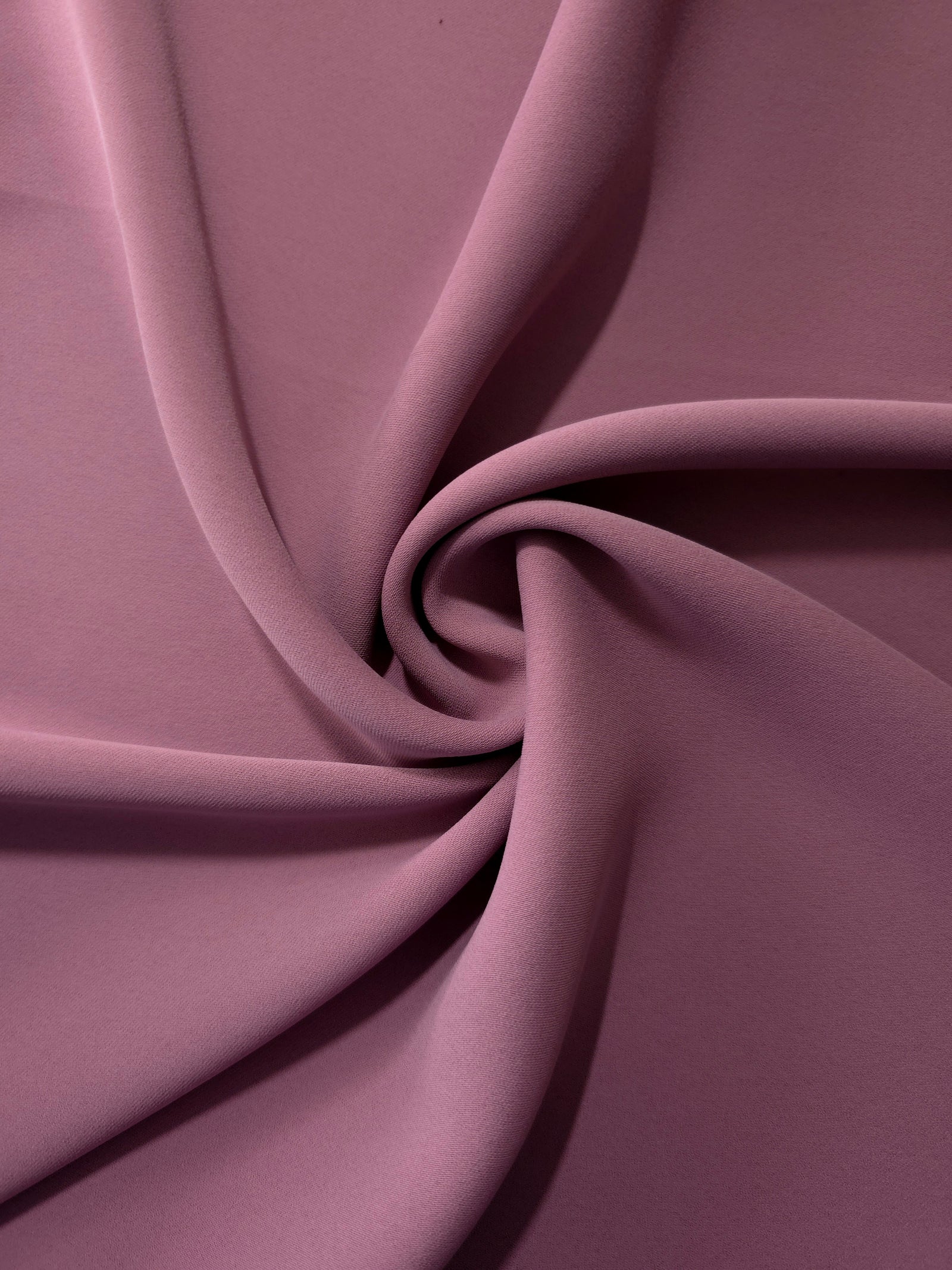 Dusty Mauve silky-soft polyester crepe styled in a swirl to show fluid dressmaking drape and movement
