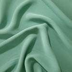 Dusty Mint Green Korean crepe displayed in fluid draped folds for eveningwear, skirts and flowing garments