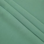 Dusty Mint Green mechanical polyester crepe in layered folds, showing gentle stretch and structure for dressmaking