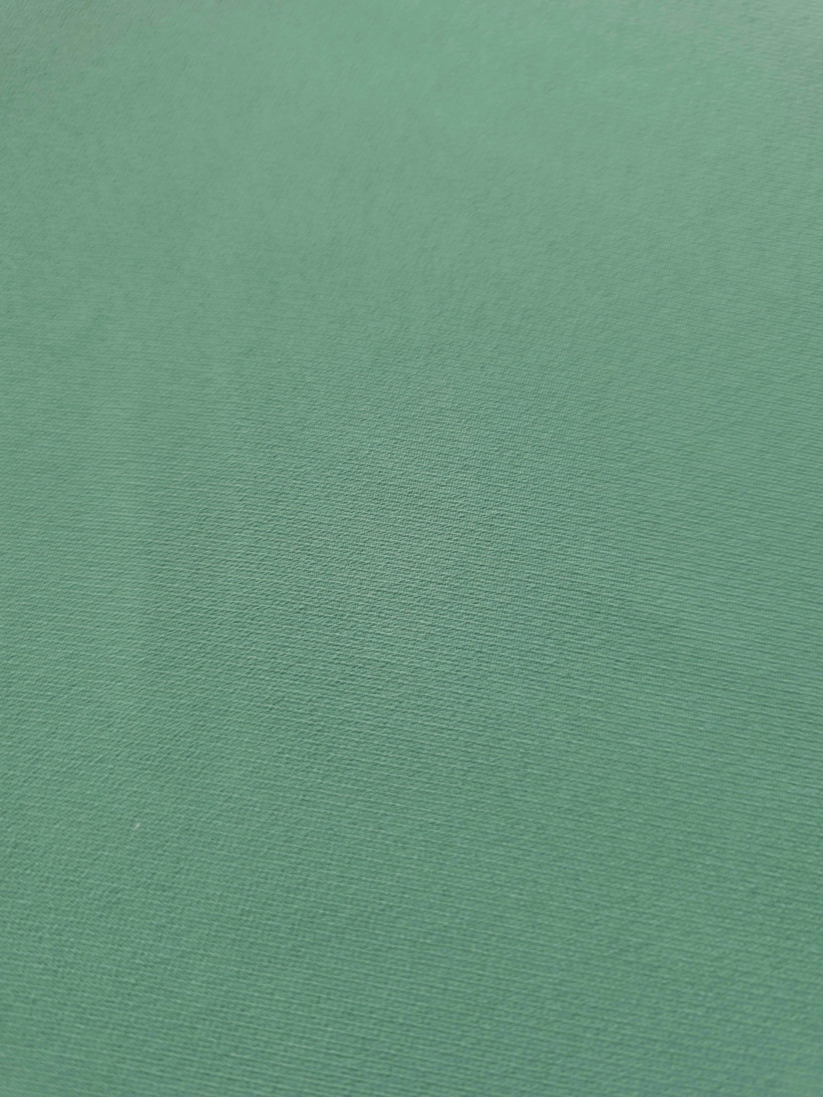 Woven close-up of Dusty Mint Green mechanical polyester crepe showing smooth texture and a soft silky-feel finish