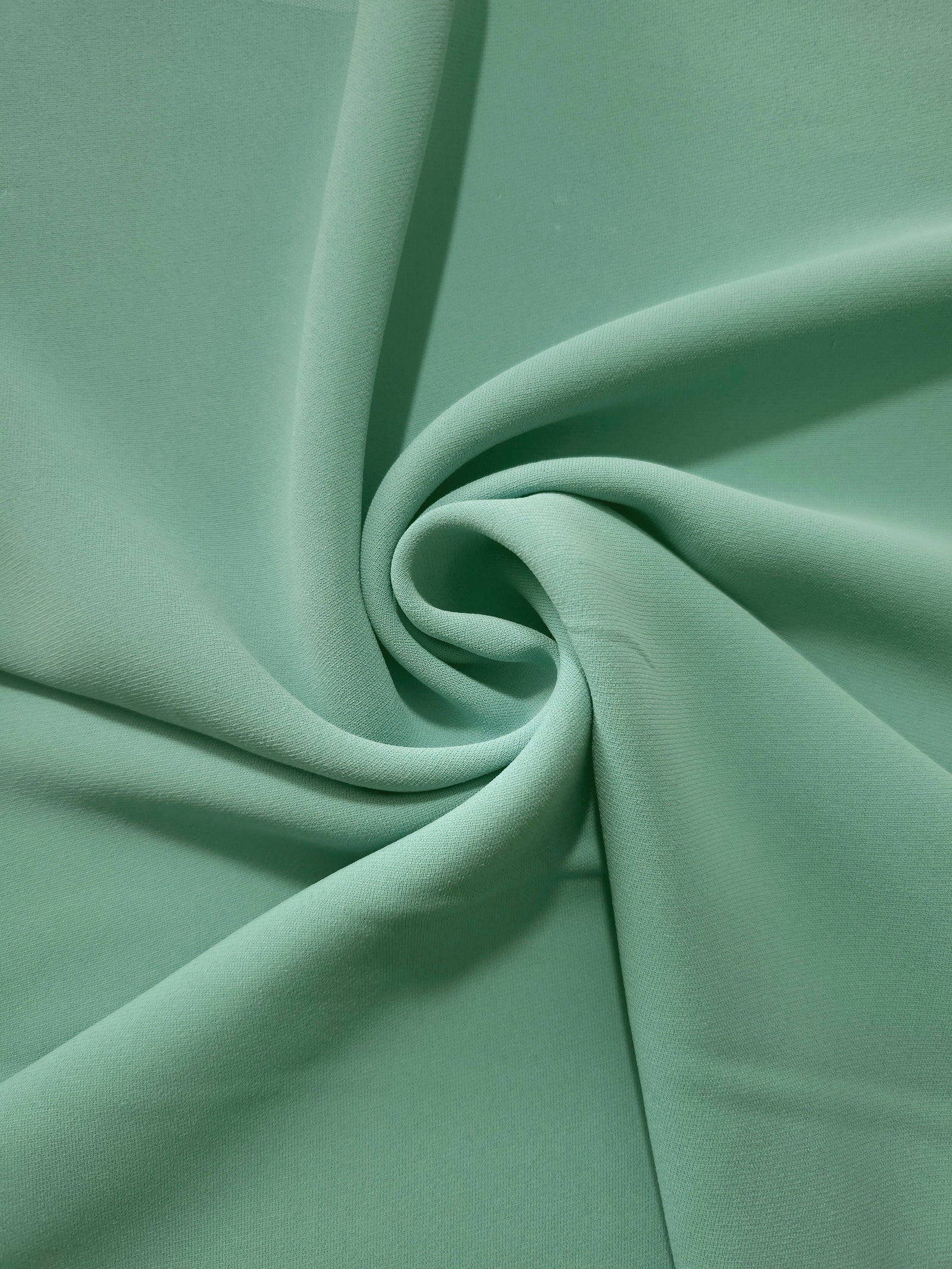 Spiral styling of Dusty Mint Green Korean polyester crepe showing supple drape for abayas, dresses and occasionwear