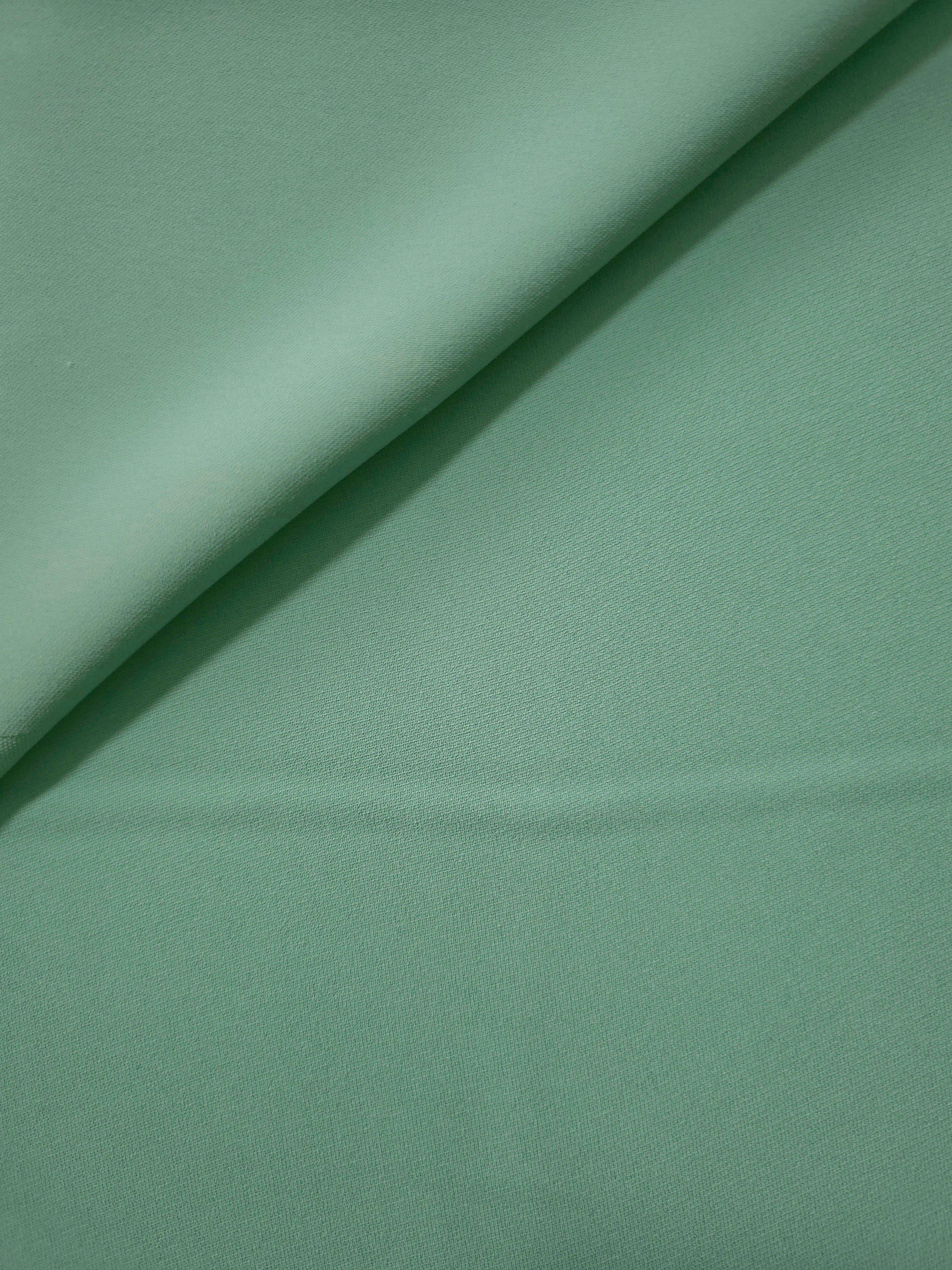 Dusty Mint Green polyester crepe gathered into a soft fold, showing fluid drape for dresses and blouse making