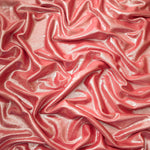 Softly draped Dusty Peach Pink foiled spandex fabric showing fluid shape and metallic shimmer for dresses, stage costumes and eventwear