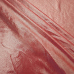 Dusty Peach Pink foiled spandex arranged in layered folds, displaying shimmer and soft structure for skirts, tops and performancewear