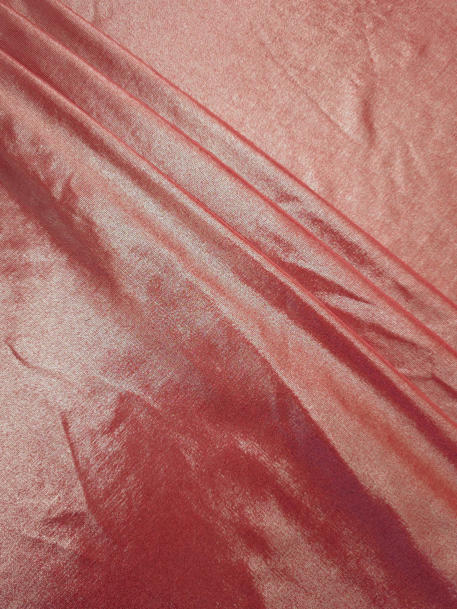 Dusty Peach Pink foiled spandex arranged in layered folds, displaying shimmer and soft structure for skirts, tops and performancewear