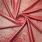 Flowing swirl of Dusty Peach Pink metallic stretch fabric, showing dynamic foil reflection for stagewear, skirts and creative fashion