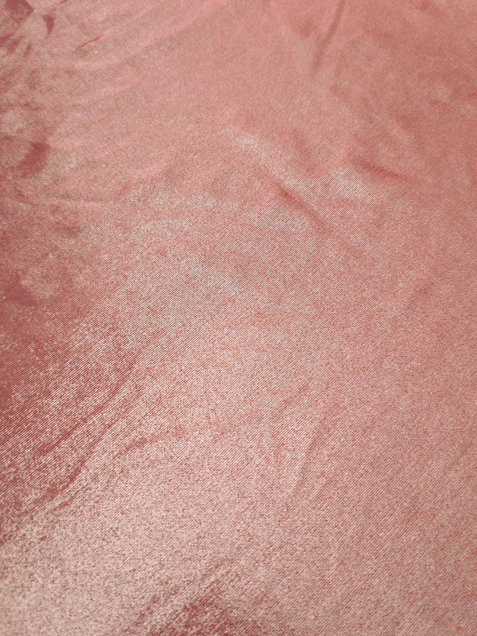 Dusty Peach Pink foiled stretch fabric texture close-up, displaying metallic reflection and fine surface character for apparel design