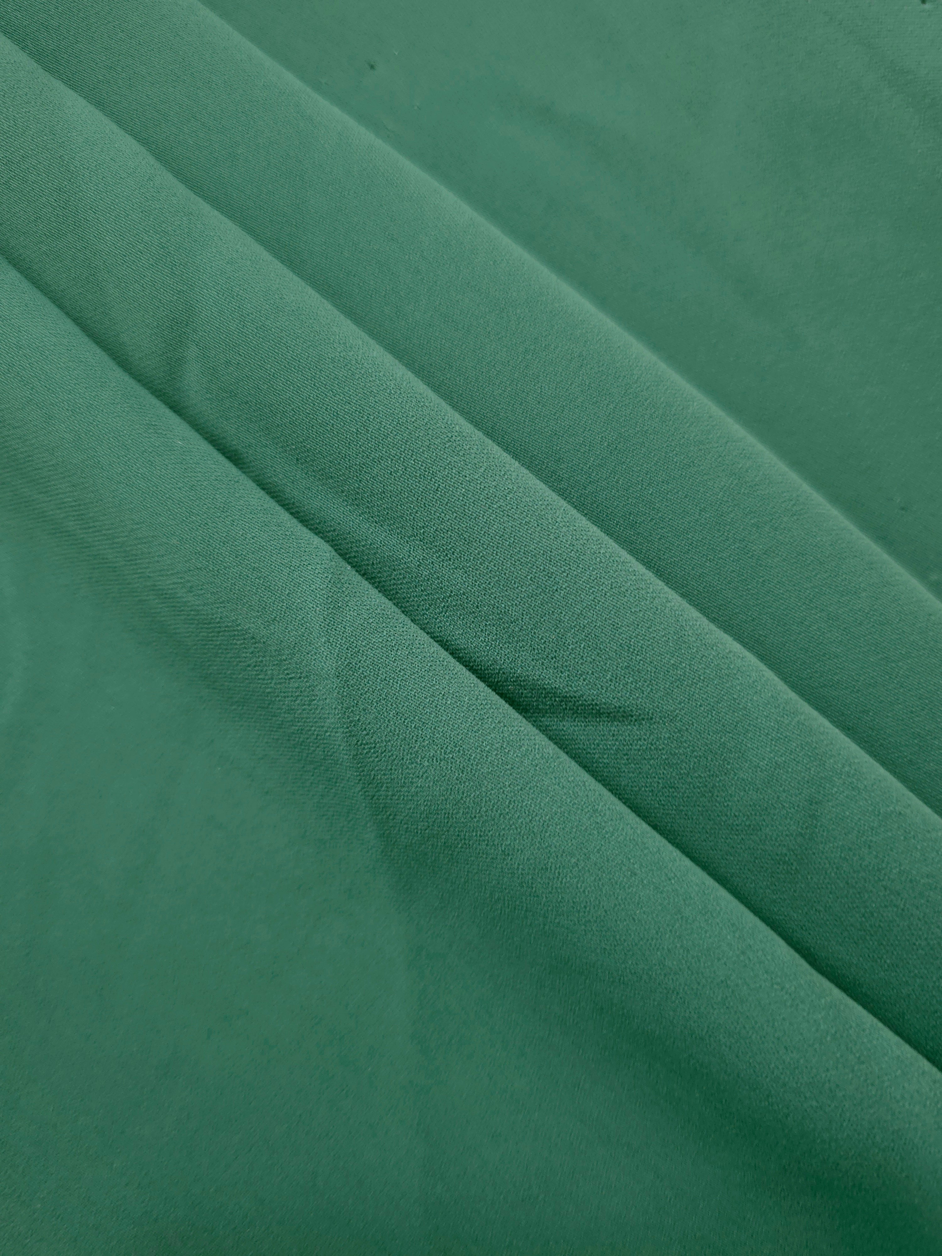 Dusty Pine Green mechanical polyester crepe in layered folds, showing soft body and gentle stretch for separates