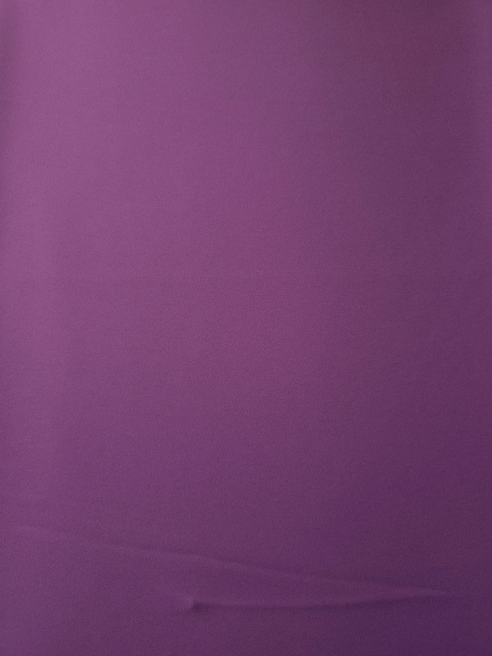 Surface view of Dusty Plum 205 GSM polyester crepe, opaque Korean dress fabric with a smooth woven finish