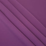 Flowing swirl of Dusty Plum Korean polyester crepe showing soft drape for blouses, dresses and abayas