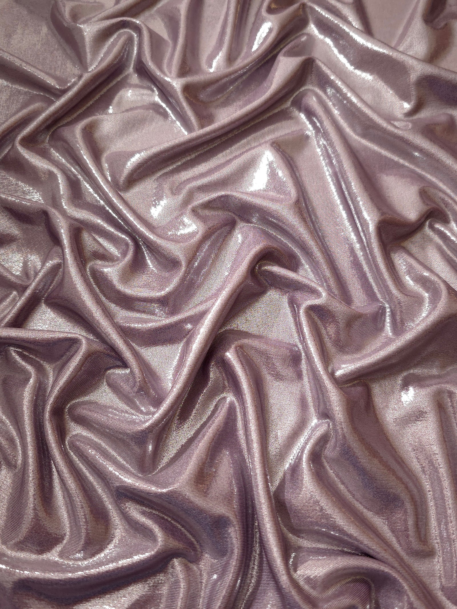 Flowing folds of Dusty Rose Mauve metallic foiled spandex, showing shimmer and drape for dancewear, party dresses and performance fashion