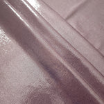 Layered folds of Dusty Rose Mauve foiled stretch fabric showing shimmer, body and movement for performance outfits and statement garments