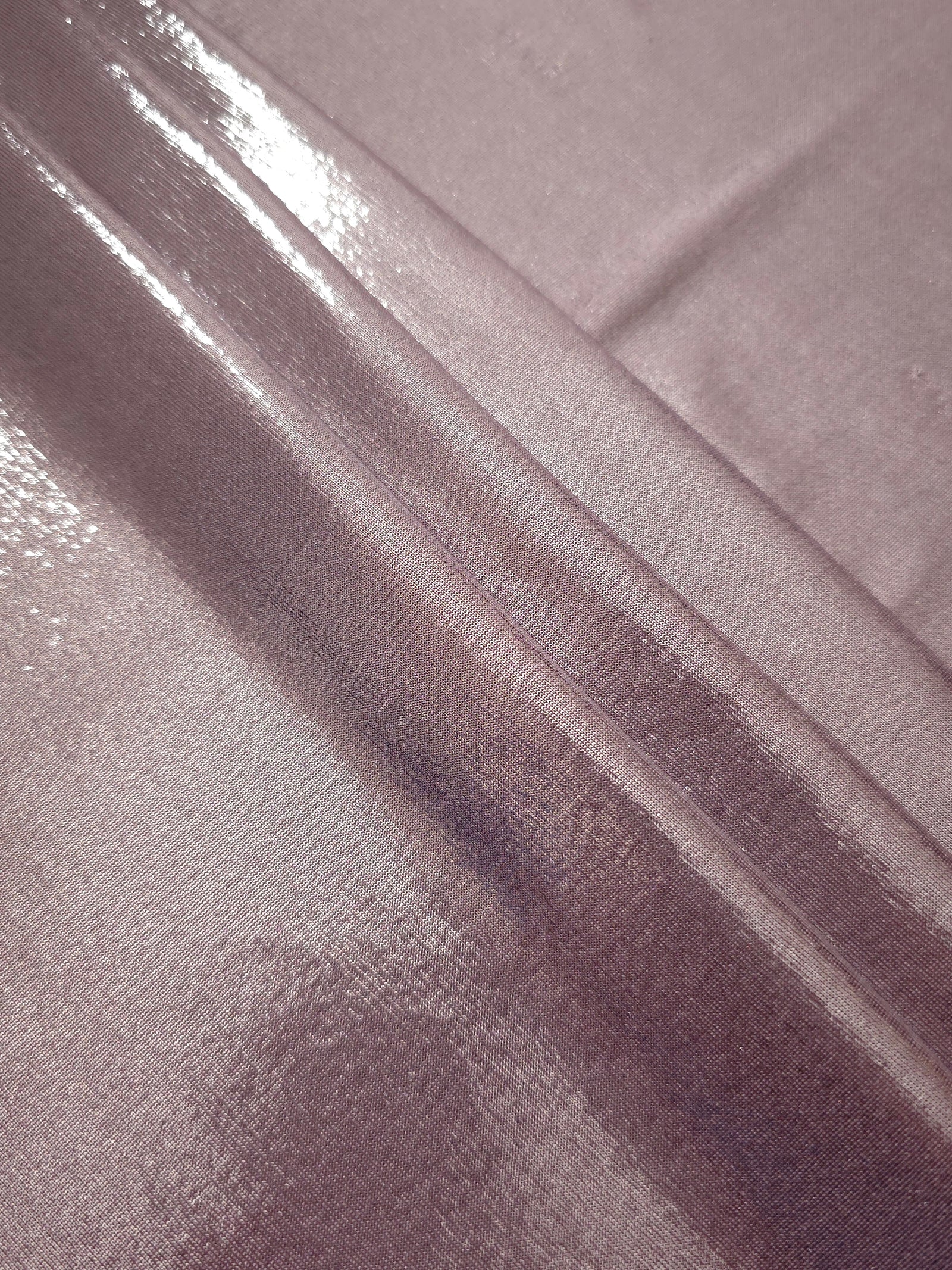 Layered folds of Dusty Rose Mauve foiled stretch fabric showing shimmer, body and movement for performance outfits and statement garments