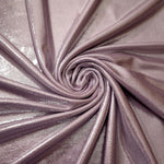Dusty Rose Mauve metallic stretch fabric in a flowing swirl, emphasizing foil shimmer and drape for partywear and statement fashion
