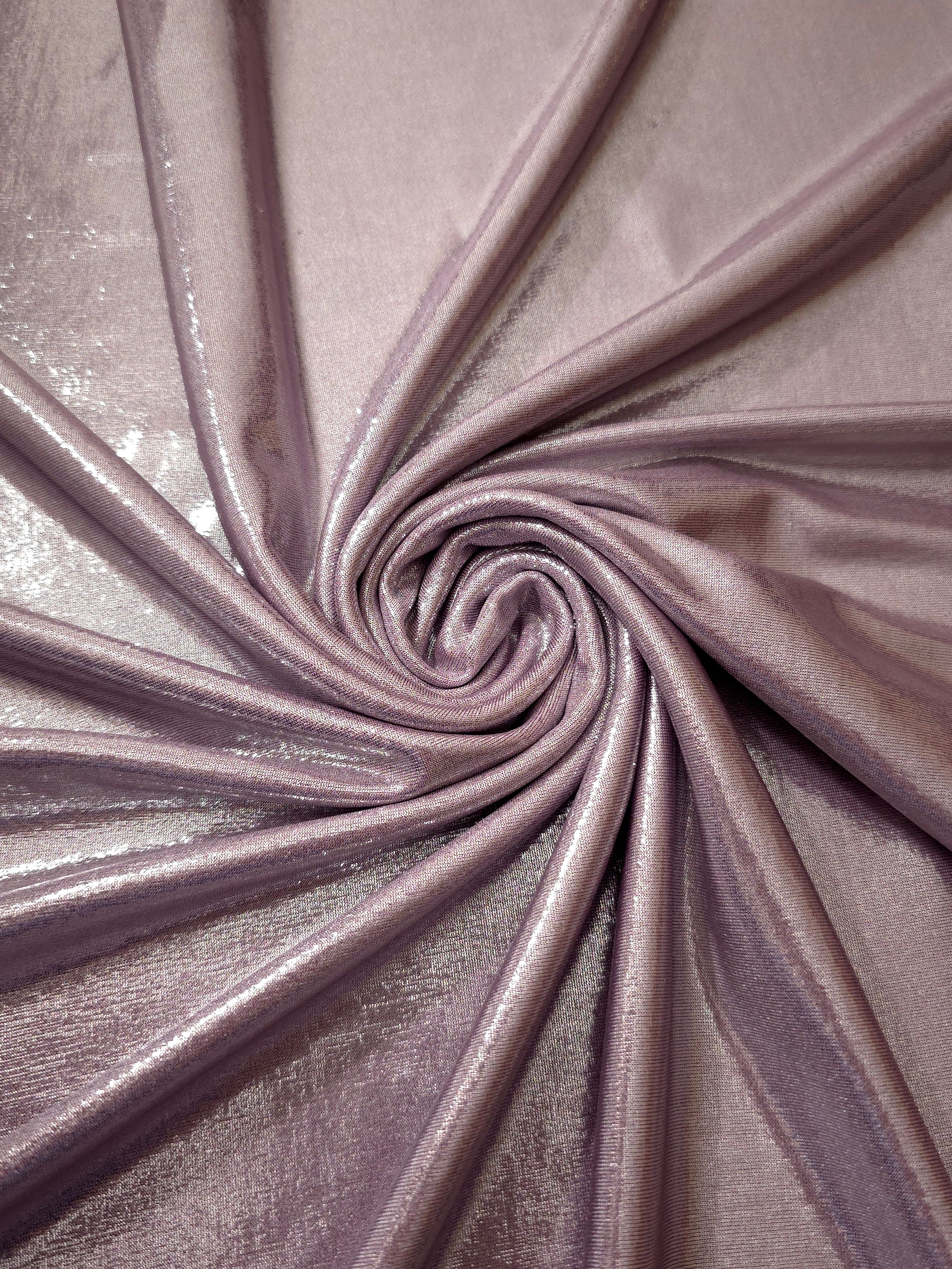 Dusty Rose Mauve metallic stretch fabric in a flowing swirl, emphasizing foil shimmer and drape for partywear and statement fashion