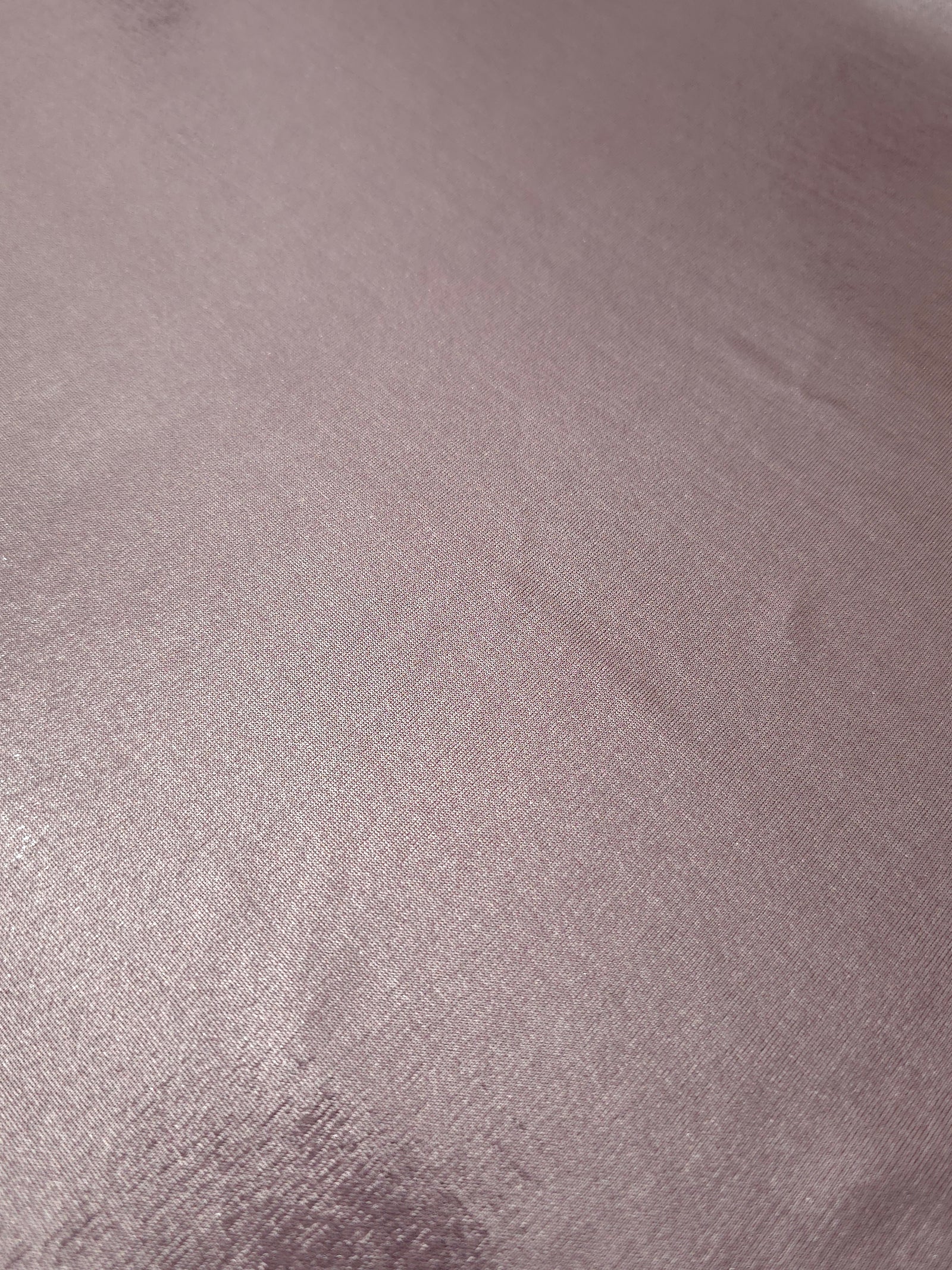 Detailed close-up of Dusty Rose Mauve foiled spandex fabric showing its luminous metallic surface and fine reflective texture