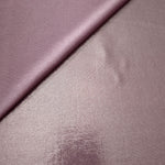 Dusty Rose Mauve foiled stretch fabric in a gentle fold, showing metallic shimmer and flexibility for partywear and performance fashion