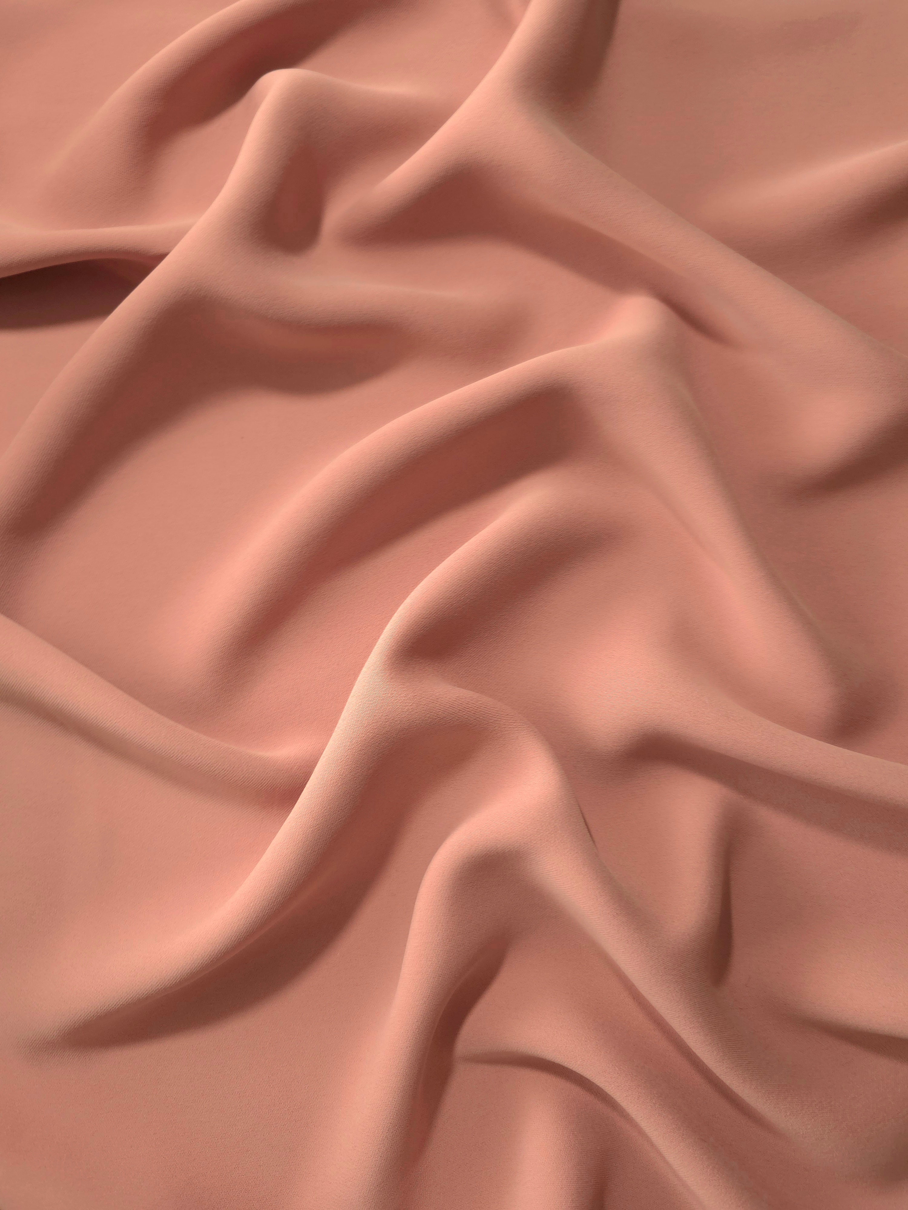 Draped folds of Dusty Rose Taupe polyester crepe showing opaque coverage and fluid movement for garment making