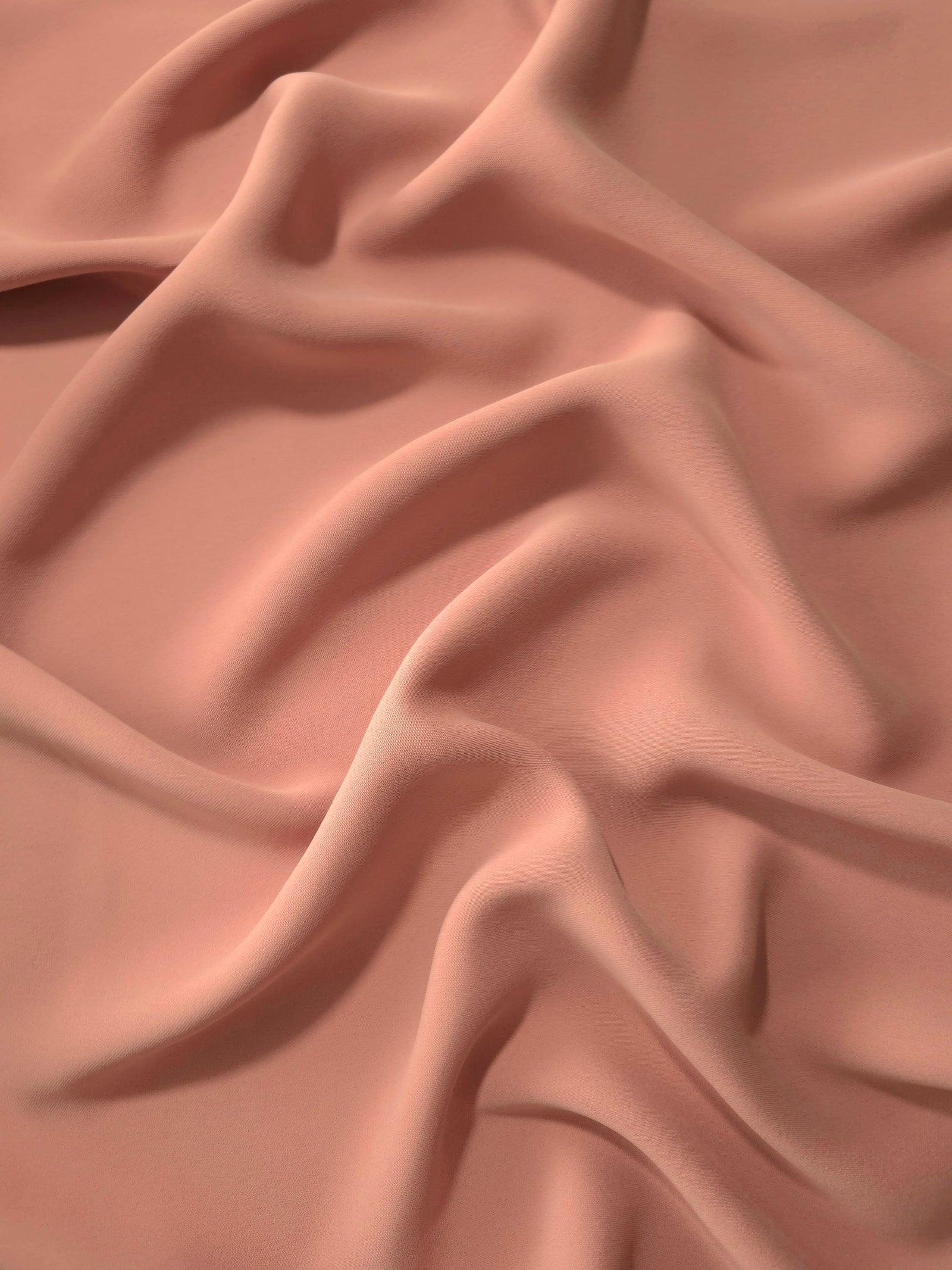 Draped folds of Dusty Rose Taupe polyester crepe showing opaque coverage and fluid movement for garment making