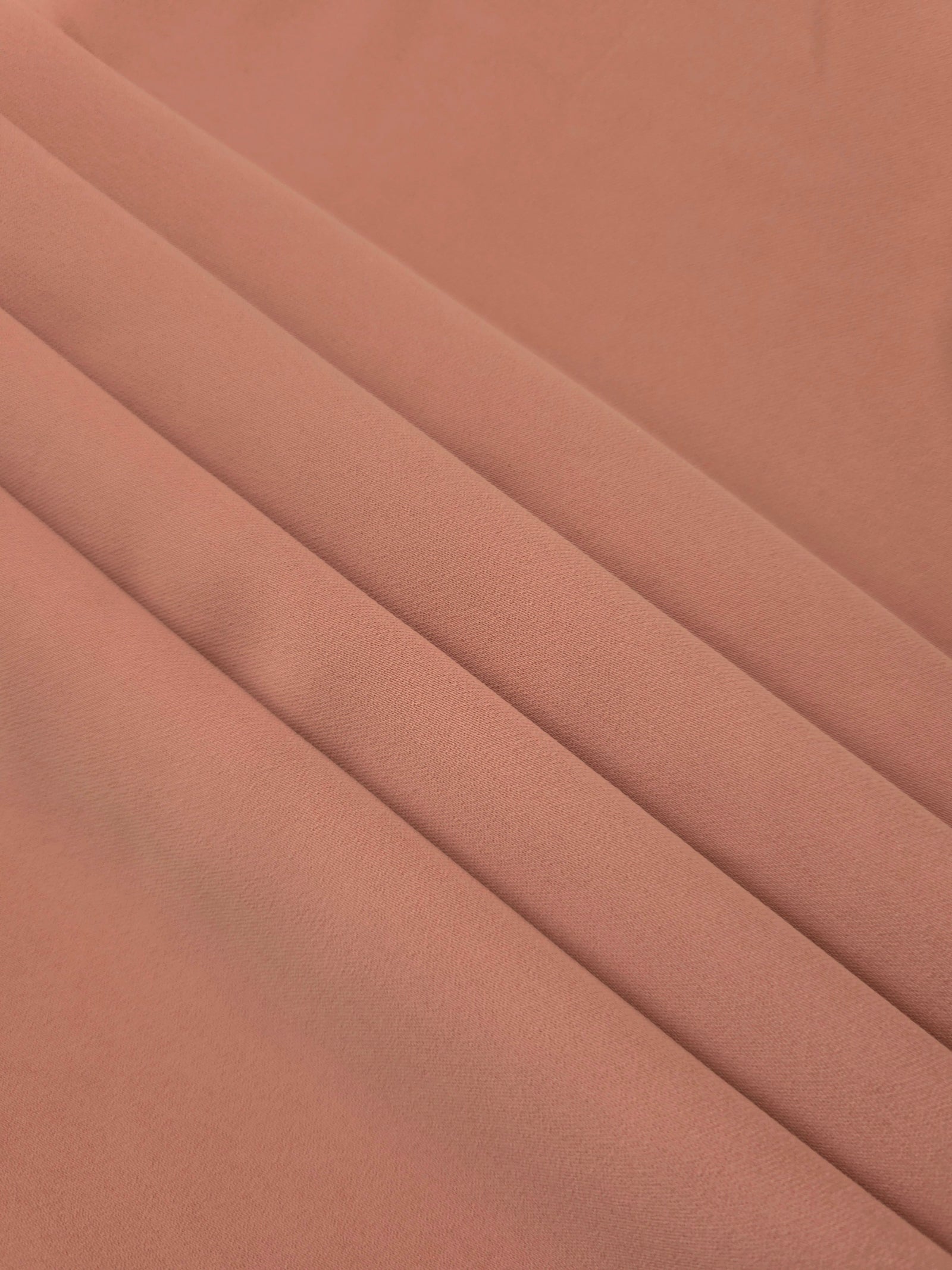 Layered Dusty Rose Taupe Korean polyester crepe showing gentle mechanical stretch and soft structure for dressmaking