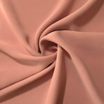 Dusty Rose Taupe silky-soft polyester crepe styled in a swirl to show fluid dressmaking drape and movement