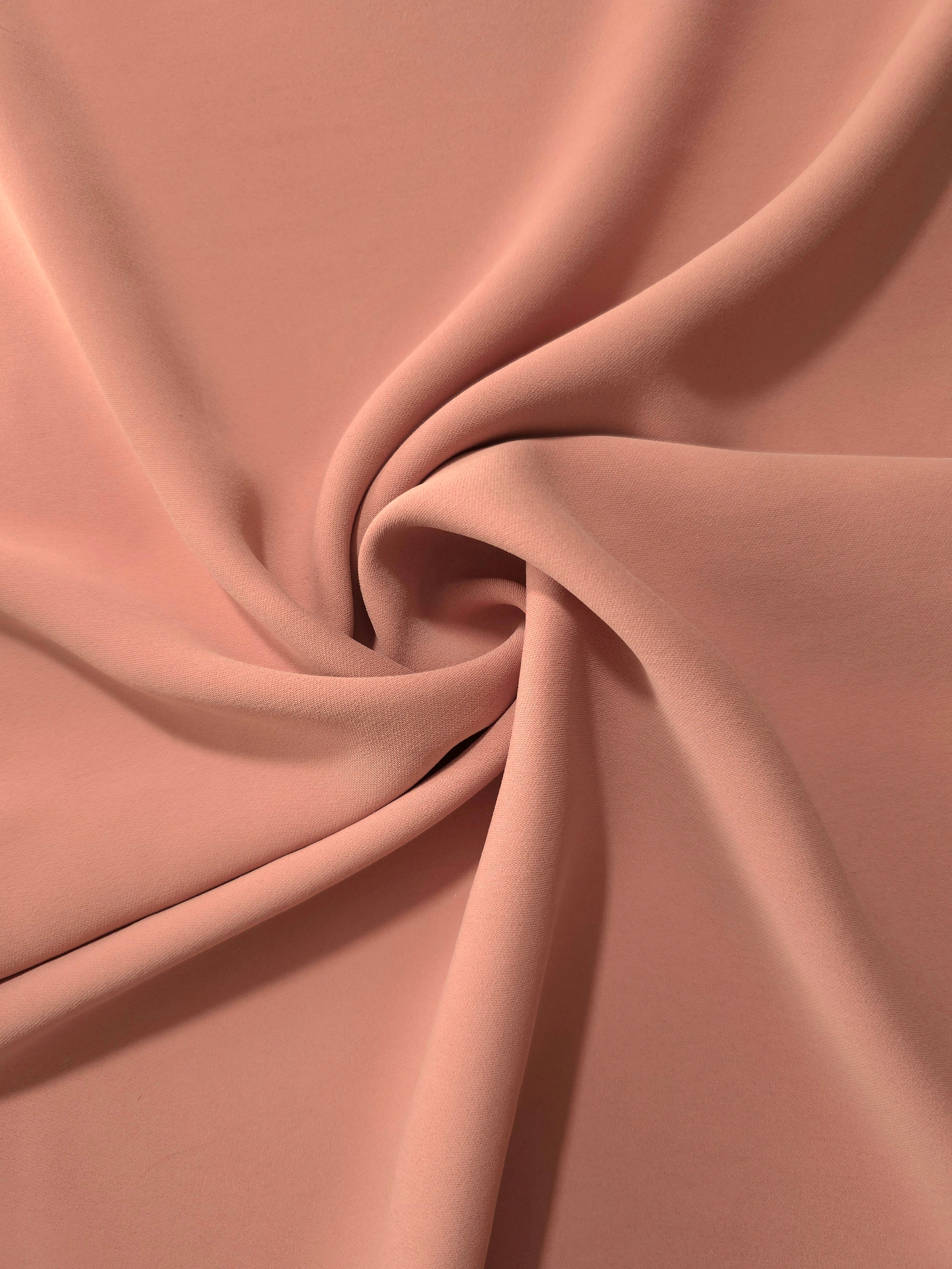 Dusty Rose Taupe silky-soft polyester crepe styled in a swirl to show fluid dressmaking drape and movement