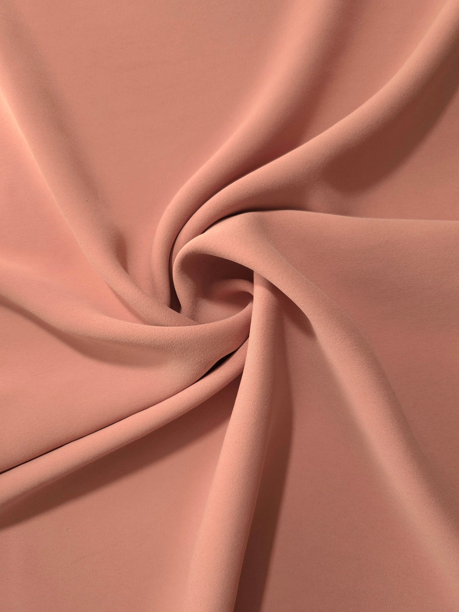 Dusty Rose Taupe silky-soft polyester crepe styled in a swirl to show fluid dressmaking drape and movement