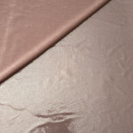 Gently folded Dusty Rose Taupe shimmer spandex fabric showing luminous foil finish for tops, skirts and occasion garments